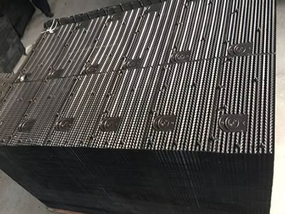 Many pieces of black cooling tower fills are piled with each other on the pallet, each piece has twelve parts with same profile.